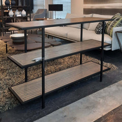 A black powder coated steel Yombe Console with three shelves, featuring a slatted wood pattern on the shelves. 